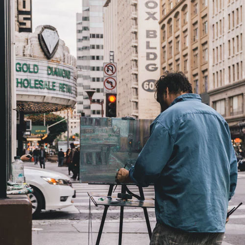 A man paints the streetscape in the historic jewelry district of downtown LA